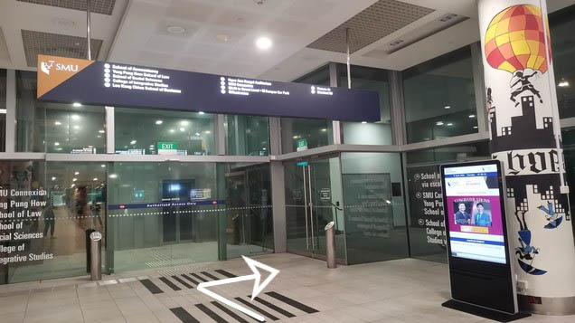 Before the lift lobby, turn right through the glass doors. Take the escalator up and turn left