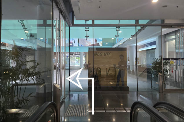 At the top of the escalator, exit from the glass doors on your left