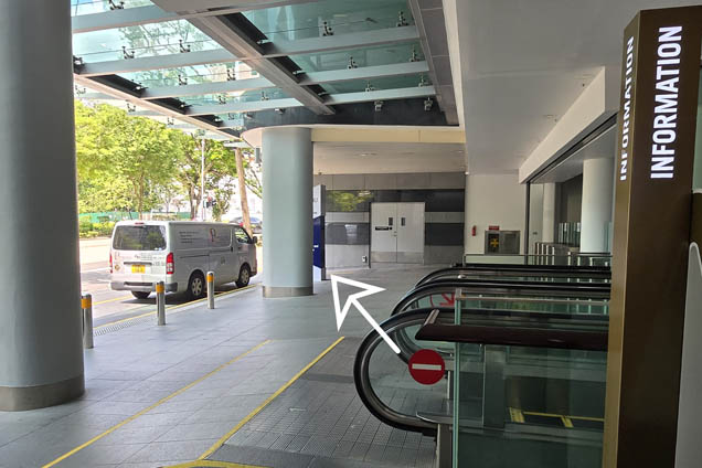 At the top of the escalator, walk on to the building signage
